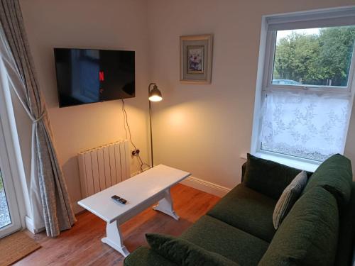 uma sala de estar com um sofá e uma mesa em The Free Range Room at The Cracked Hen em Gorey