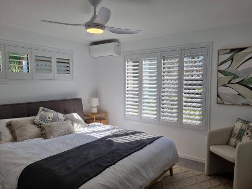 une chambre avec un lit et un ventilateur de plafond dans l'établissement SeaEstaAtMoffatQuietbeachParklargefenced yard, à Caloundra