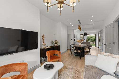 a living room with a couch and a tv at The North Kensington House in London