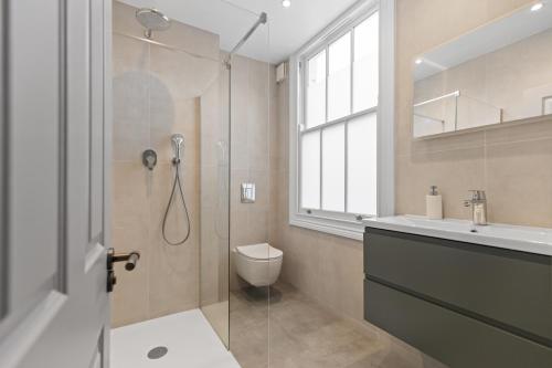 a bathroom with a shower and a toilet and a sink at The North Kensington House in London