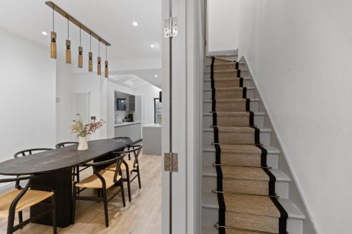 a staircase leading up to a dining room with a table and chairs at The North Kensington House in London
