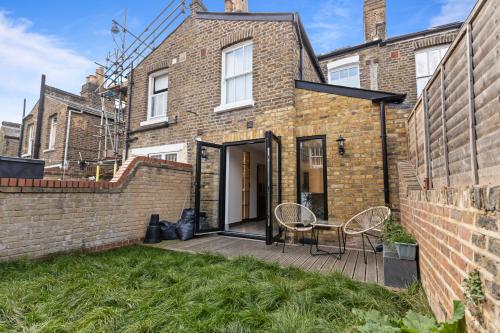 a brick house with a patio and a table at The North Kensington House in London