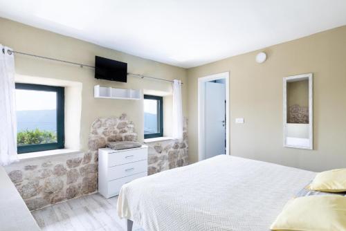 een slaapkamer met een wit bed en 2 ramen bij Duka by Vintage Travel in Butkovine