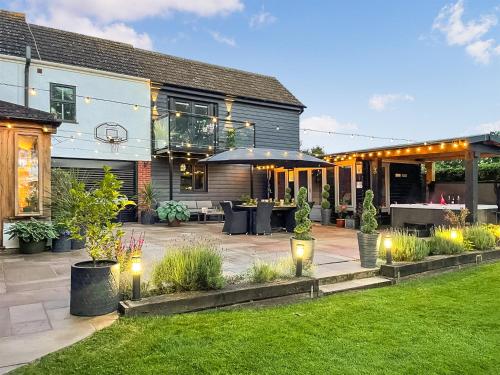 eine Terrasse mit Lichtern im Hof eines Hauses in der Unterkunft Myrtle Cottage in Potter Heigham