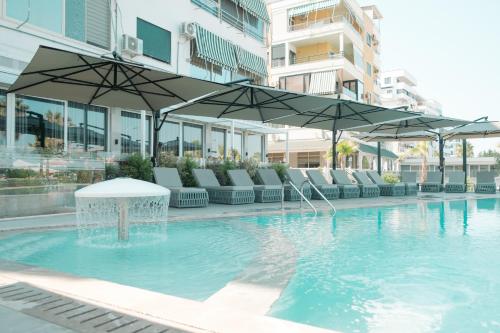a swimming pool with chairs and umbrellas in a building at Blue Studios by Comfort Suites in Golem