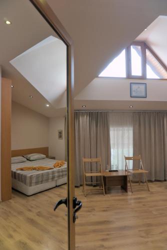 a bedroom with a bed and a table and a window at Todorovi Guest House in Stara Zagora
