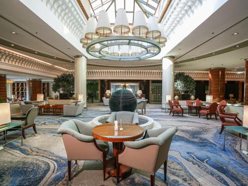 a lobby with chairs and tables and a chandelier at Sheraton Dammam Hotel & Convention Centre in Dammam
