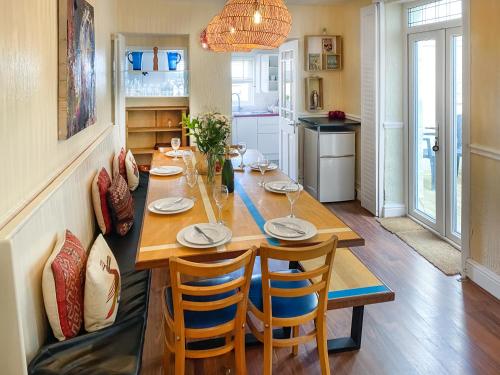 a dining room with a wooden table and chairs at Bora House in Newquay
