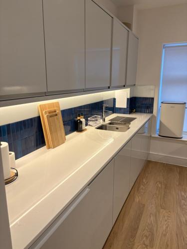 a kitchen with white cabinets and a sink at Cozy Bedroom in a Townhouse Next to Jewellery Quarters and City Centre in Birmingham