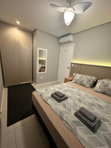 a bedroom with a bed with two towels on it at Apto lindo e completo com piscina em Itajai in Itajaí