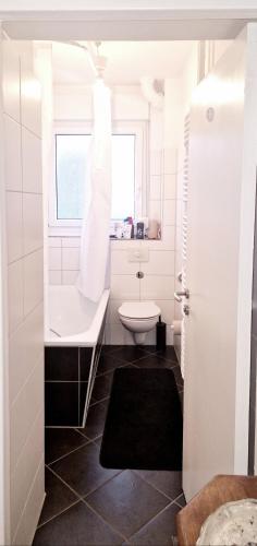 a white bathroom with a sink and a toilet at Tripplezimmer mit Garten, Kicker und Grill in Berlin