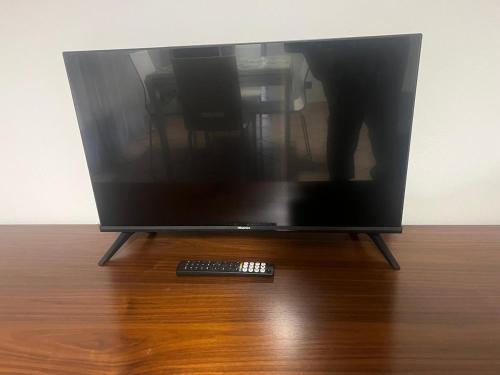 a television screen with a remote control on a wooden floor at Humanitas, Forum center Milano Trilo with Terrazzo in Rozzano