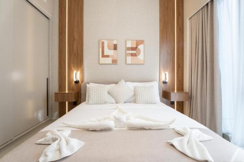 a bedroom with a white bed with towels on it at 1BR in GRANDE with Balcony I Amazing INFINITY POOL I Steps to Dubai Mall & Fountain in Dubai