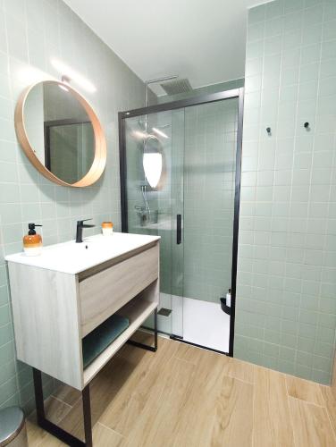 a bathroom with a sink and a shower with a mirror at l'Alqueria de Laguar - Casa rural al Barranc de l'Infern in Benimaurell