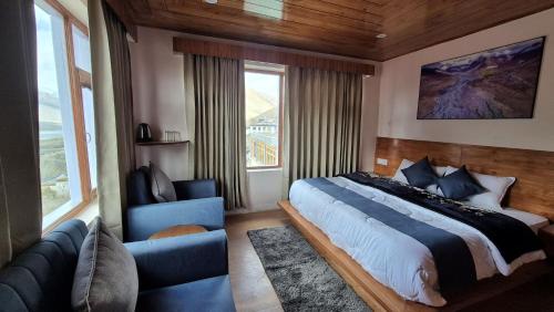 a bedroom with a bed and a couch and a window at The White Mountain Stays in Kibar