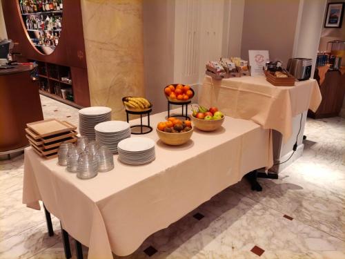 two tables with plates and bowls of fruit on them at Hôtel de la Paix Lausanne in Lausanne