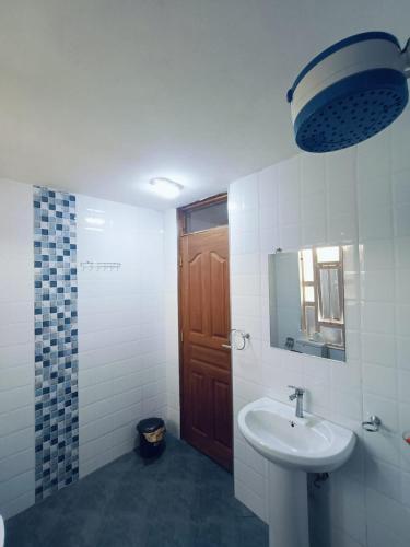a bathroom with a sink and a mirror and a door at The Cliff in Nairobi