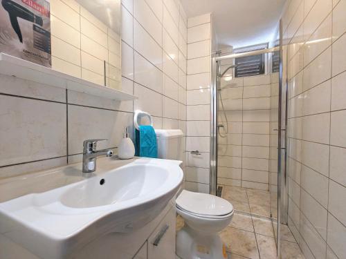 a bathroom with a sink and a toilet at Robinson Monte Cristo in Bogomolje