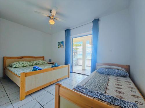 a bedroom with two beds and a ceiling fan at Robinson Monte Cristo in Bogomolje