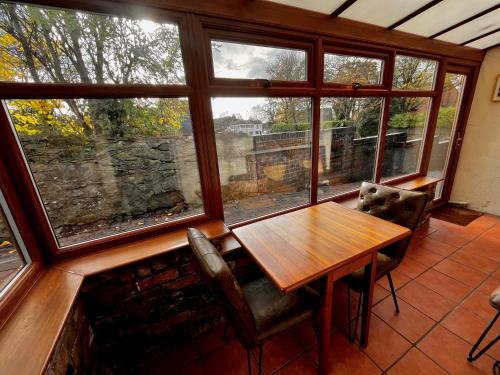 a dining room with a table and a large window at Squirrel Cottage in Stoke on Trent