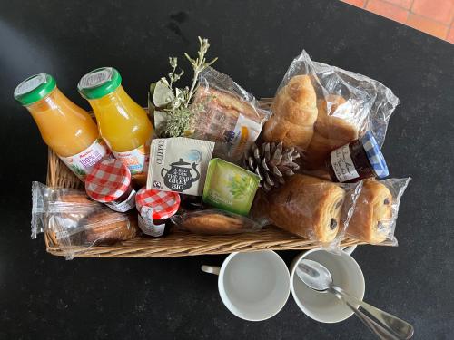a basket filled with bread and drinks and pastries at le cocon de la Bouille in La Bouille