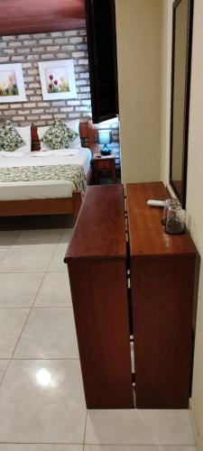 a hotel room with two beds and a desk in a room at Pousada Ponta dos Anéis in Maracajaú