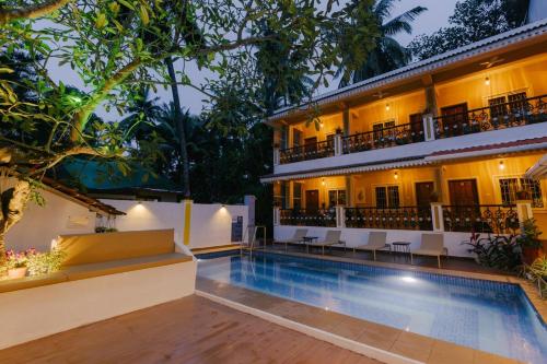 a hotel with a swimming pool in front of a building at Pvt Pool - Villa Azura Escape Marialina Calangute in Saligao