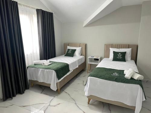 a bedroom with two beds and a window at Royal Suit in Bandırma