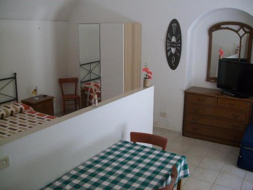 1 dormitorio con cama, mesa y espejo en Appartamento Mariana, en Matera