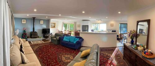 a living room with a couch and a kitchen at Govetts Leap lookout cottage with sauna in Blackheath