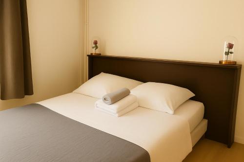 a bedroom with a bed with two pillows at Hôtel Le Paris Brest in Lens