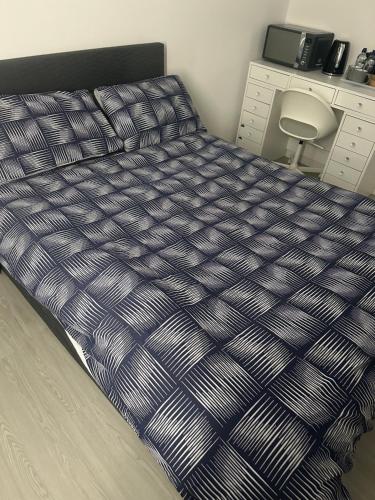 1 cama con edredón azul y blanco en una habitación en The Courtyard, en Navan