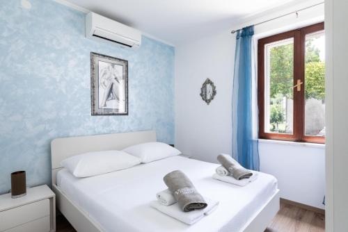 a bedroom with a white bed and a window at Sele by Vintage Travel in Gruda