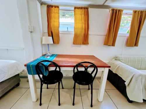 a room with a table with two chairs and a bed at White Pearl at Strand in Strand