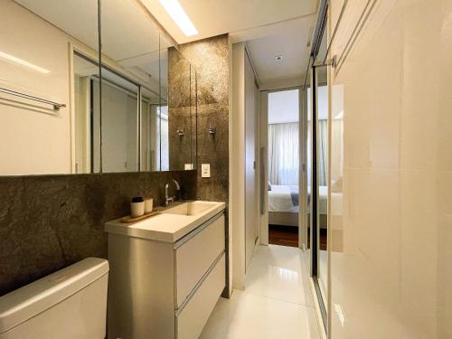 a bathroom with a sink and a mirror and a tub at Brisas do Cabo Branco by Hosppedar in Tambaú