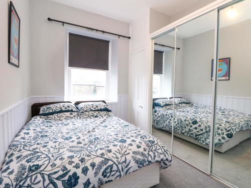 a bedroom with a bed and a mirror at 9A Market Square in Stonehaven