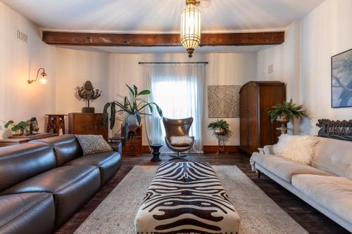a living room with a leather couch and a rug at Norfolk House Fremantle in Fremantle