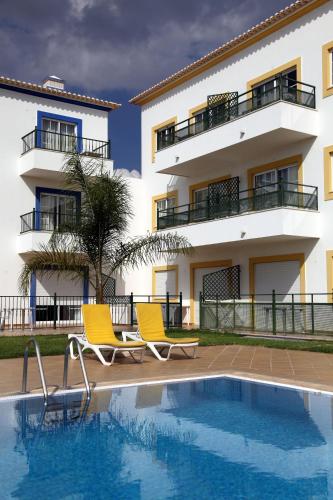 a building with two chairs next to a swimming pool at Alagoa Azul in Altura
