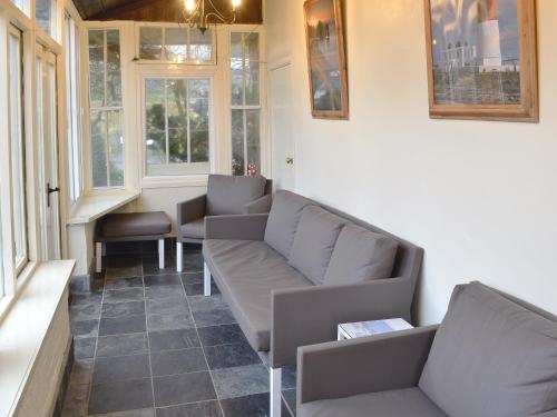 a waiting room with couches and windows at Swiss Cottage in Chideock