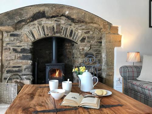 a table with a book and a fireplace at Lightfoot House in Redmire