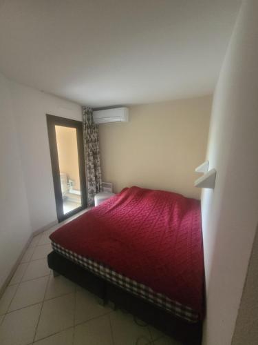 Chambres charmantes dans un appartement moderne à deux pas de la mer في كان: غرفة نوم بسرير احمر ونافذة