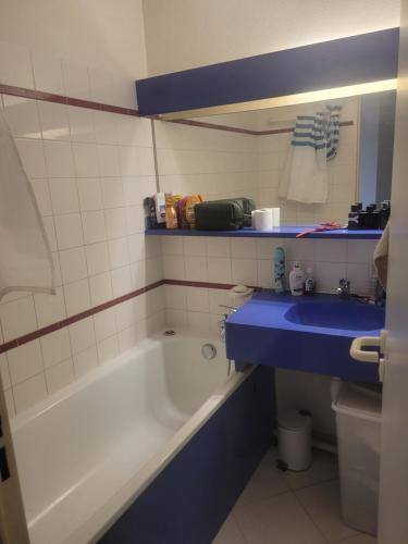 Chambres charmantes dans un appartement moderne à deux pas de la mer في كان: حمام مع حوض استحمام ومغسلة زرقاء