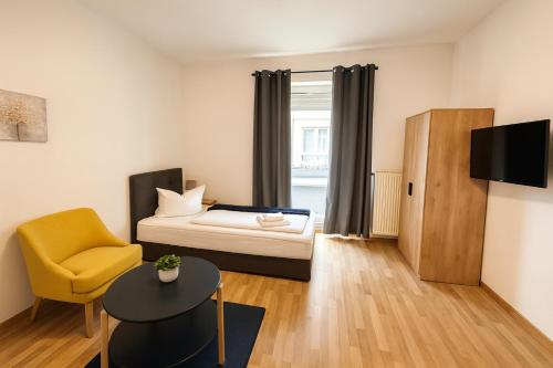 una pequeña habitación con una cama y una silla en SUNNYHOME Monteurwohnungen und Apartments in Bodenwöhr, en Bodenwöhr