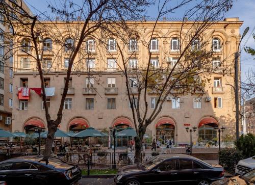 エレバンにあるApartment KeyGo #0201 next to the National Galleryの大きな建物の前に駐車した車両2台