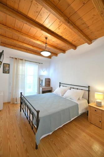 a bedroom with a large bed with a wooden ceiling at Zoe's and Leonard's Houses in Hydra