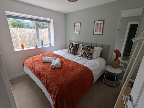 a bedroom with a bed with two towels on it at Ruskin Apartment - Free Parking - 2 Bedrooms - Sleeps 3 in Midsomer Norton