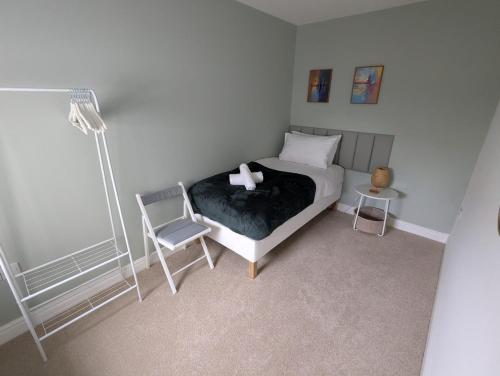 a bedroom with a bed with a chair and a lamp at Ruskin Apartment - Free Parking - 2 Bedrooms - Sleeps 3 in Midsomer Norton