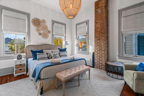 une chambre avec un lit, une chaise et des fenêtres dans l'établissement The White Pelican Inn-Trolley a 5 Minute Walk Stops at SeawallBeach, à Galveston