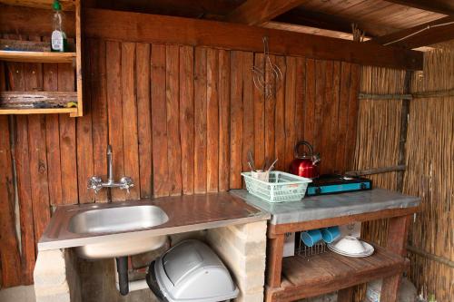 cocina con fregadero en una pared de madera en Chobe Hideaway, en Kasinka