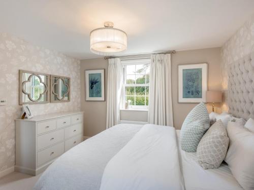 a white bedroom with a large bed and a window at Pass the Keys Former Show Home 6 min walk to Deddington in Deddington